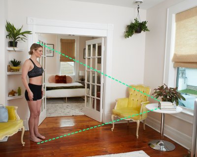 Woman Standing in Her Room Scanning Herself With the SureFit Application